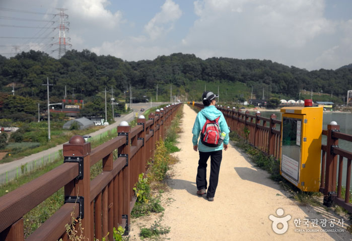 Un voyageur marche sur une rive d'un réservoir d'eau - Siheung, Gyeonggi-do, Corée (https://codecorea.github.io)