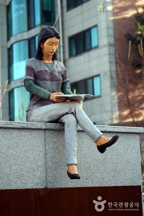 Eine Frau liest ein Buch am Eingang der Gyeongui Seonseo Straße - Mapo-gu, Seoul, Korea (https://codecorea.github.io)
