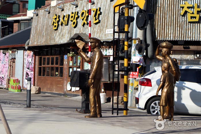 Une statue représentant un gardien de gare et une famille essayant de traverser la rue - Mapo-gu, Séoul, Corée (https://codecorea.github.io)