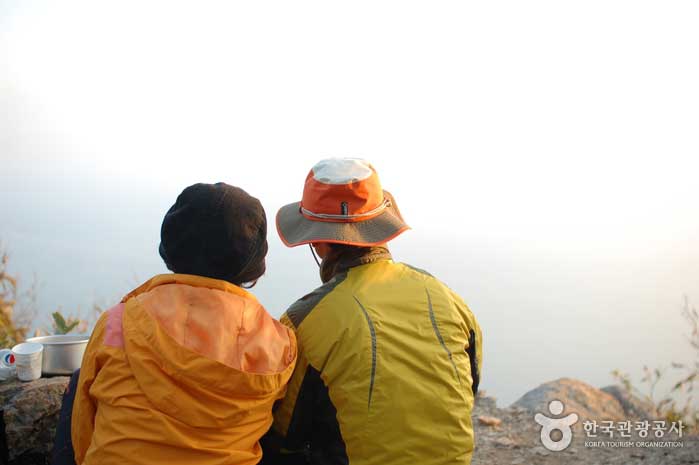 Paar mittleren Alters, das nebeneinander sitzt und Gogunsan-gun ansieht - Gunsan, Jeonbuk, Korea (https://codecorea.github.io)