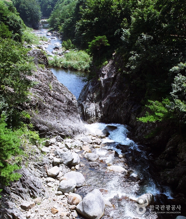 Вода течет через скалы под обрывом. - Янъян-гун, Канвондо, Корея (https://codecorea.github.io)