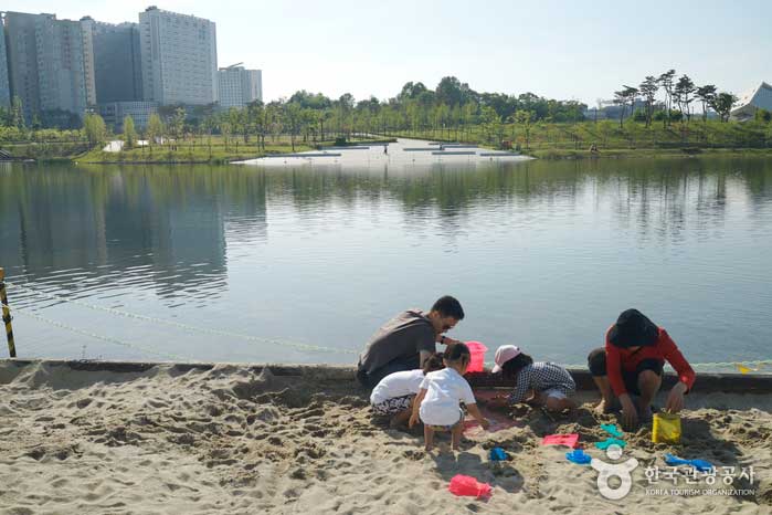 Famille jouant avec du sable sur la plage d'argent - Sejong, République de Corée (https://codecorea.github.io)