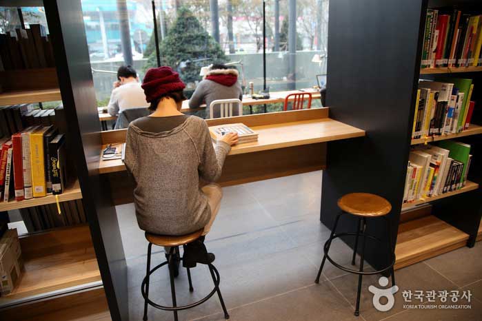 本棚の間のシンプルなテーブルに座っているゲスト - 韓国京畿道城南市 (https://codecorea.github.io)