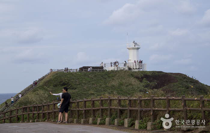Lovers taking a selfie against the backdrop of a lighthouse - Jeju City, Jeju, Korea (https://codecorea.github.io)