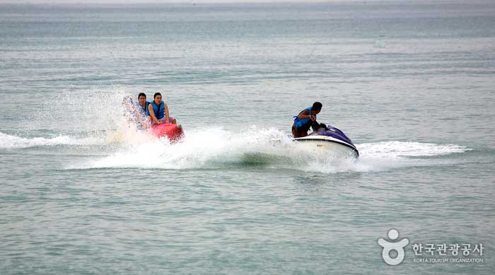 Leute, die Bananenboote am Jikyungri Strand reiten - gegen... (https://codecorea.github.io)
